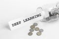 Sticking out of a jar of coins a piece of paper with a text Deep Learning on a white background