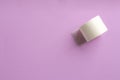 Sticking plaster roll on lilac background, top view. Space for text