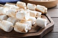 Sticks with roasted marshmallows on wooden table, closeup