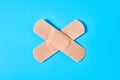 Sticky medical patch in form of cross on blue background