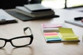 sticky note, eyeglasses, notebook on office desk. business, work