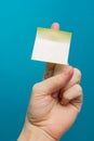 Sticky note, finger up of thumb, yellow reminder on blue background. Royalty Free Stock Photo