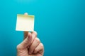 Sticky note, finger up of thumb, yellow reminder on blue background. Royalty Free Stock Photo