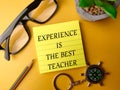 Sticky note and glasses with the word EXPERIENCE IS THE BEST TEACHER Royalty Free Stock Photo