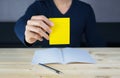 Sticky note holding by man hand, sitting on wooden work desk Royalty Free Stock Photo