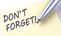 Sticky Note Message DON`T FORGET with pen on white background Royalty Free Stock Photo