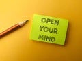 Sticky note and pencil with the word OPEN YOUR MIND Royalty Free Stock Photo