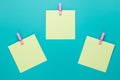 Sticky note with pink pin on turquoise background. Yellow stickers on a green background, top view. Blank notes on notice board. B Royalty Free Stock Photo