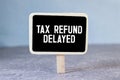 Sticky note with the text Tax Refund Delayed on Income Tax form background with calculator Royalty Free Stock Photo