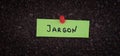 A sticky note with the word Jargon on it pinned to a cork board