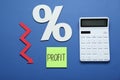 Sticky note with word Profit, calculator, percent symbol and up arrow on blue background, flat lay Royalty Free Stock Photo