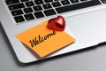 Sticky note with word Welcome and candy on laptop, closeup Royalty Free Stock Photo