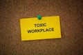 A sticky note with the words Toxic Workplace on it pinned to a cork board Royalty Free Stock Photo