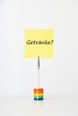 Sticky notepaper with German text GetrÃÂ¤nke? (drinks) clipped to a multicolored card holder