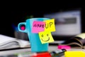 Sticky notes on a coffe cup at office desk. Wake up and smile. Begin your day with Positive thoughts