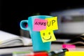 Sticky notes on a coffe cup at office desk. Wake up and smile. Begin your day with Positive thoughts Royalty Free Stock Photo