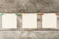Sticky notes with pins in a row on a wooden background. Royalty Free Stock Photo