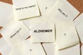 Sticky notes with questions and word alzheimer on board, alzheimer`s disease concept