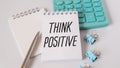 Sticky notes with think positive message and calculator on white background Royalty Free Stock Photo
