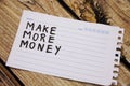 sticky with the phrase make more money written on it. room for text. on the wooden background