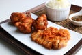 Sticky rice with fried pork served with Jaew Thai dipping sauce, placed on a wooden tray