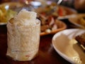 Sticky rice in small serving bamboo basket on a defocused background of variety of Thai foods Royalty Free Stock Photo