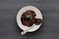 Sticky toffee sponge cake, with a sticky toffee sauce, on a white plate with a spoon, on a dark grey wooden surface with space for Royalty Free Stock Photo