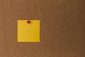 Sticky yellow note on cork board close up