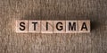 STIGMA - word written on wooden blocks on a brown background