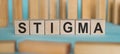 STIGMA word written on wooden blocks on light blue background