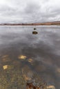 The still clear water of Loch Ba in the central part of Rannoch Moor on a wet rainy day in April. Royalty Free Stock Photo