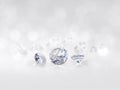 Still with expensive cut diamonds in front of a white background, reflections on the ground. Lot of copyspace Royalty Free Stock Photo
