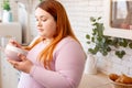 Serious red haired woman looking into the bowl Royalty Free Stock Photo