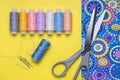 Still life with accessories for needlework. Bright fabric, scissors, pins, threads on reels. Royalty Free Stock Photo