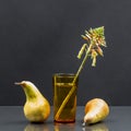 Still life with aloe vera flower in a glass of water and pears