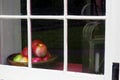 A still-life with apples in a bowl by the window.