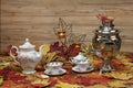 Still life art photography with an antique samovar with autumn leaves on a wooden background