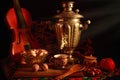 Still life art photography concept with antique samovar and violin isolated on a black background