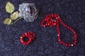 Still life of artificial rose with red beads and bracelet on textile background Royalty Free Stock Photo