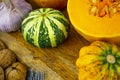 Still life with autumn vegetables and fruits on wooden background. Pumpkins, butternut, garlic