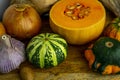 Still life with autumn vegetables and fruits on wooden background. Pumpkins, butternut, garlic