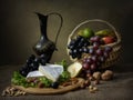 Still life with basket of fruits and cheese on the table Royalty Free Stock Photo