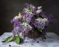 Still life with basket of lilac and lily of the valley Royalty Free Stock Photo