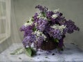 Still life with basket of lilac and lilyes of the valley Royalty Free Stock Photo