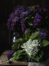 Still life with basket of lilac and lilyes of the valley Royalty Free Stock Photo