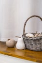 Still life - a basket of porcelain ceramic fruits in neutral colors on a window sill, closeup