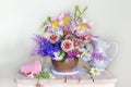 Still life with beautiful flowers in a vase on a table on a white background Royalty Free Stock Photo