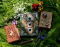 Still life with beautiful magic book of spells or diary with flowers against green leaves. Occult, esoteric and witchcraft concept Royalty Free Stock Photo