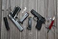 Still life of black and silver handgun with cartridge magazine, flashlight, small knife and multipurpose tool