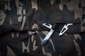 Still life of black and chrome multifunctional pocket tool and small knife on camouflage soldier pant Royalty Free Stock Photo